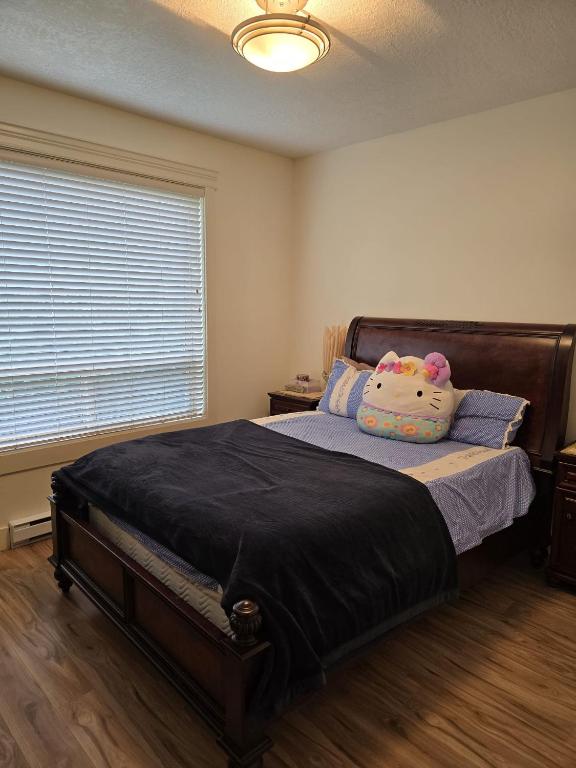a bedroom with a bed with a teddy bear pillow at Bright Private Room in Echo Valley Home in Victoria