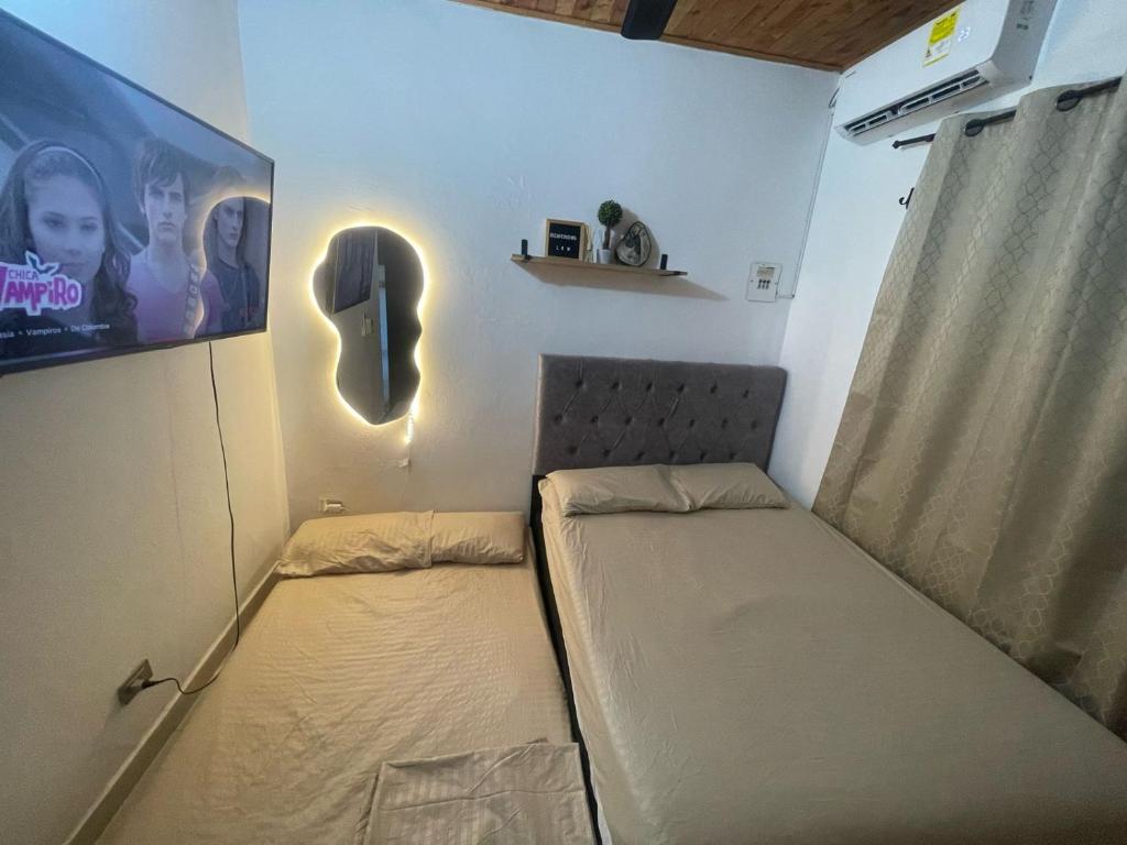 Habitación pequeña con cama y cartel en la pared en Hospedaje LunaDorada en Doradal, en Puerto Triunfo