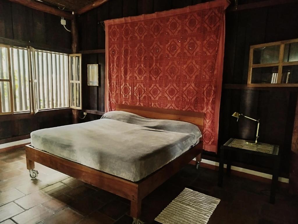a bedroom with a bed and a red wall at Casa Nalu in San Juan del Sur