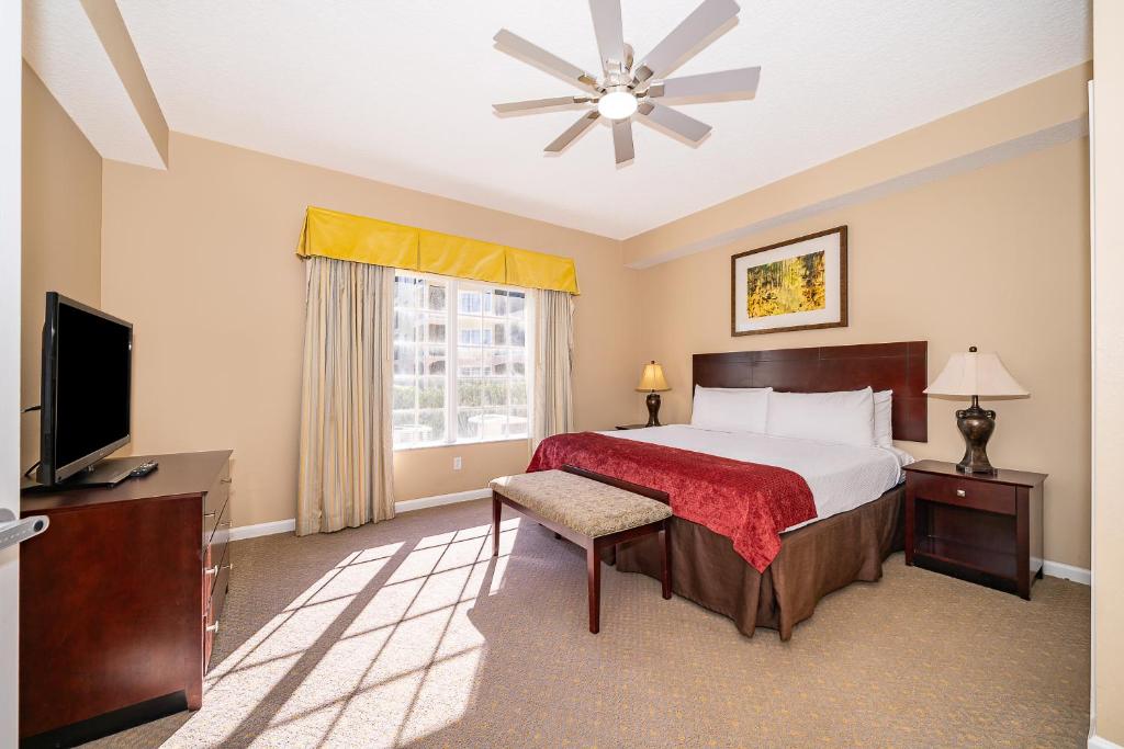 ein Schlafzimmer mit einem großen Bett und einem Fernseher in der Unterkunft Pura Vida a Private Master Bedroom with shared living space in Orlando