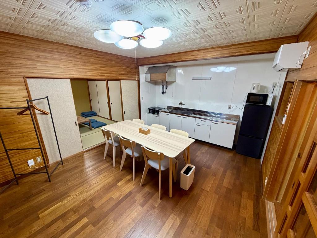 a kitchen with a table and chairs in a room at Nomad Kumano in Nachikatsuura