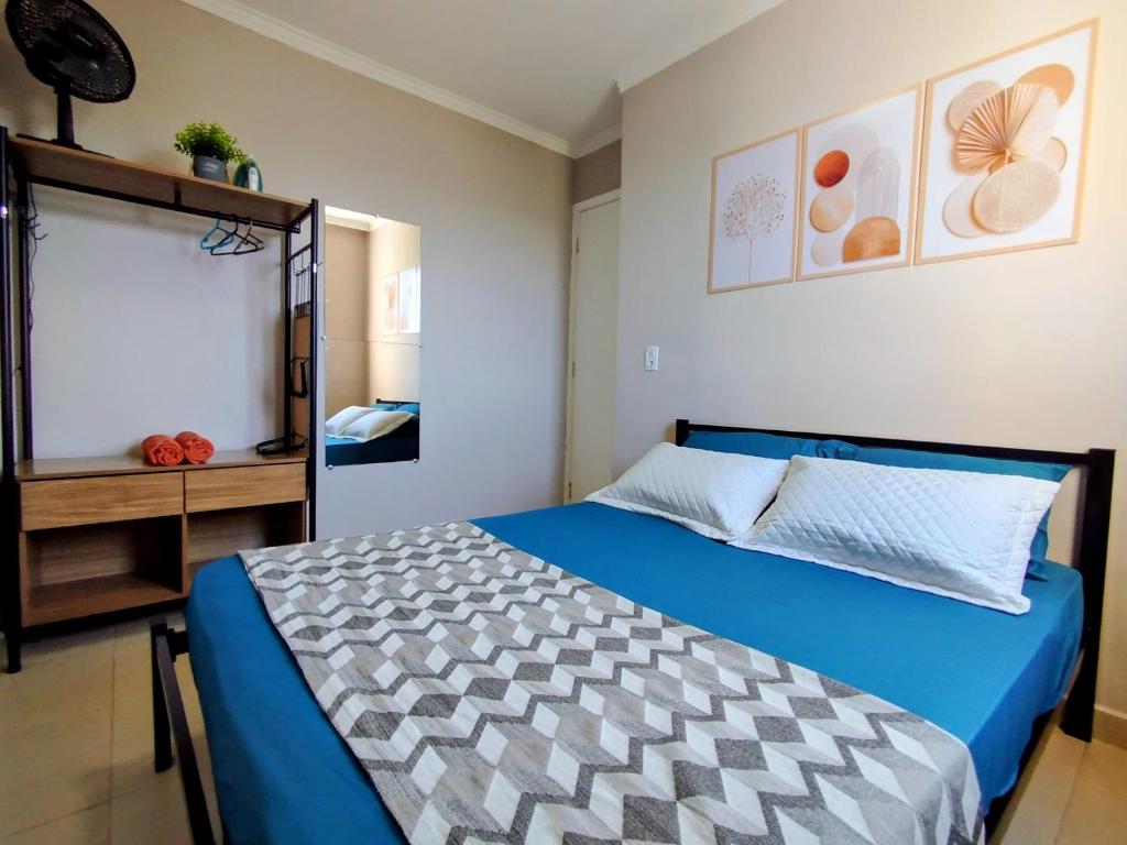コチアにあるApartamento Ao lado Animalia Park com piscina e estacionamentoの青い掛け布団が敷かれたベッドのある寝室