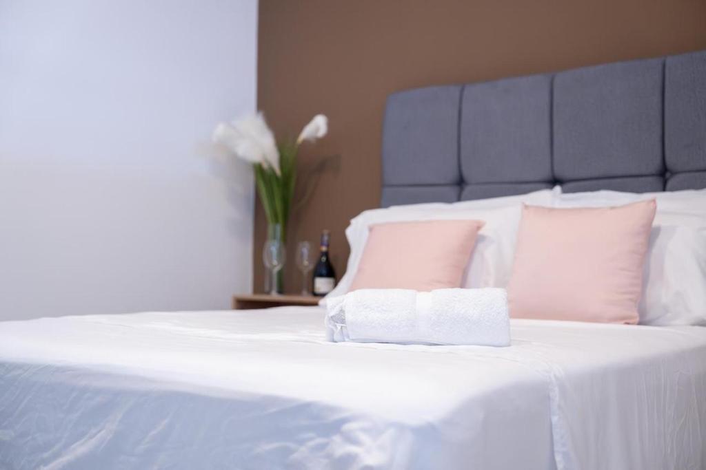 a white bed with a blue headboard and pink pillows at Hotel El Cedro Exclusive in Florencia