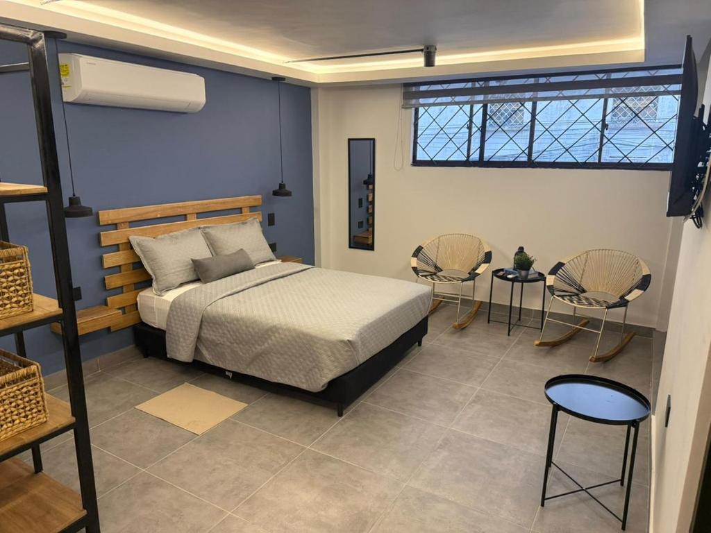 Un dormitorio con una cama y dos sillas y una mesa. en Living Sincelejo, en Sincelejo