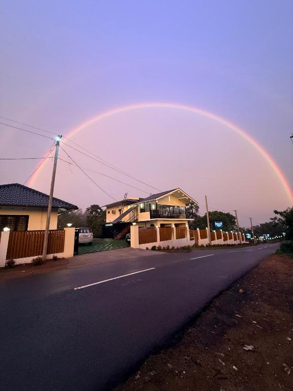 a rainbow in the sky over a street at Kenza Retreat in Vagamon