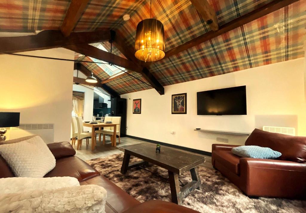Balmoral Lodge, King Size Apartment by The Hive WA1 في وارينغتون: غرفة معيشة بها أريكة وطاولة