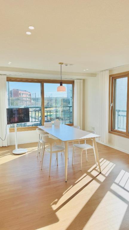 a dining room with a white table and chairs at 함덕우리집 in Hamdŏng-ni