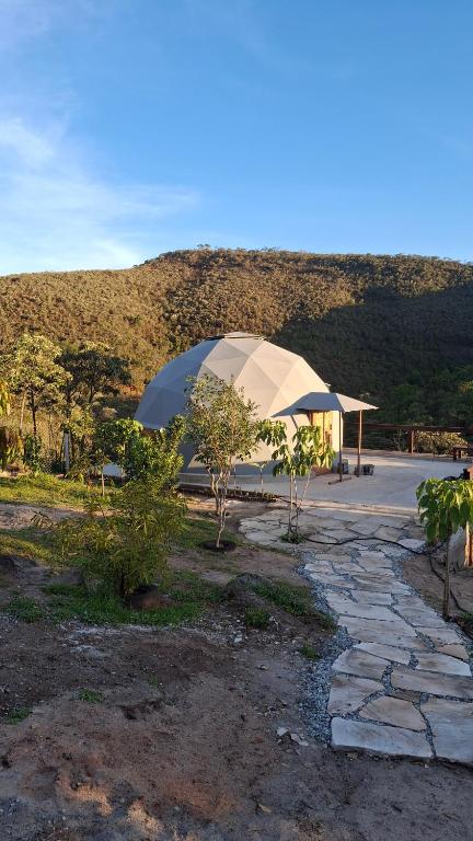 a large tent in a parking lot next to a mountain at Zaca Domos l Ouro Preto - MG in Mariana