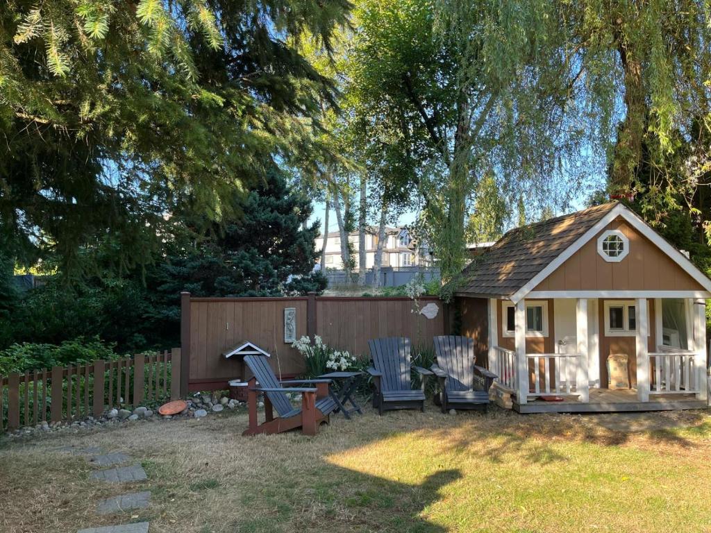 una piccola casa con sedie e un tavolo in un cortile di Surrey Home - King George Blvd & Rapid Transit - Airport 25 Min - Free Parking & Wi-Fi a Surrey