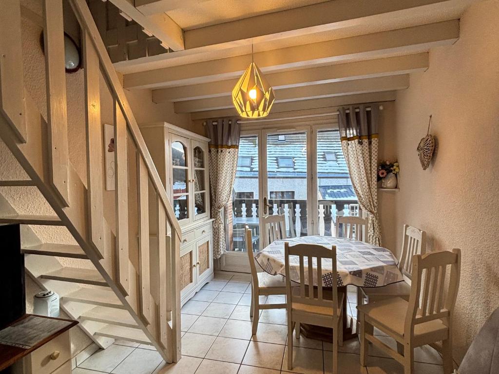 a dining room with a table and a chandelier at Charmant T3 au cœur du village pour 5 personnes - FR-1-761-31 in Villard-de-Lans