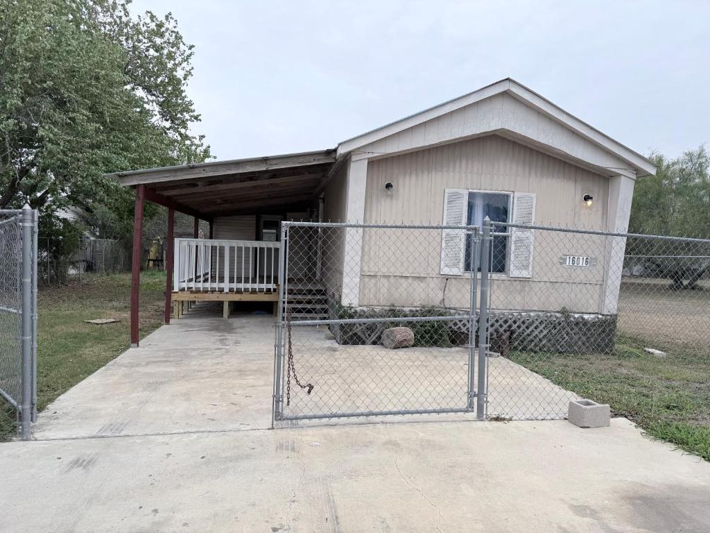 a building with a gate in front of a house at spacious one Bedroom mobil home in Harlingen