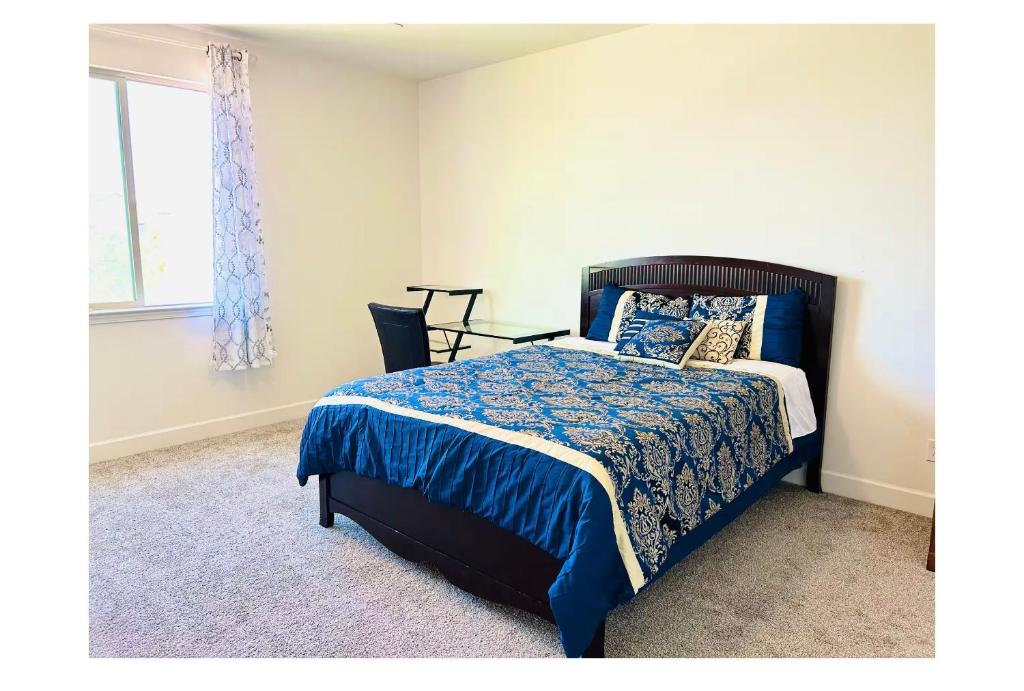 a bedroom with a bed with a blue comforter and a window at Cozy Private master bedroom in a single family house in Elk Grove