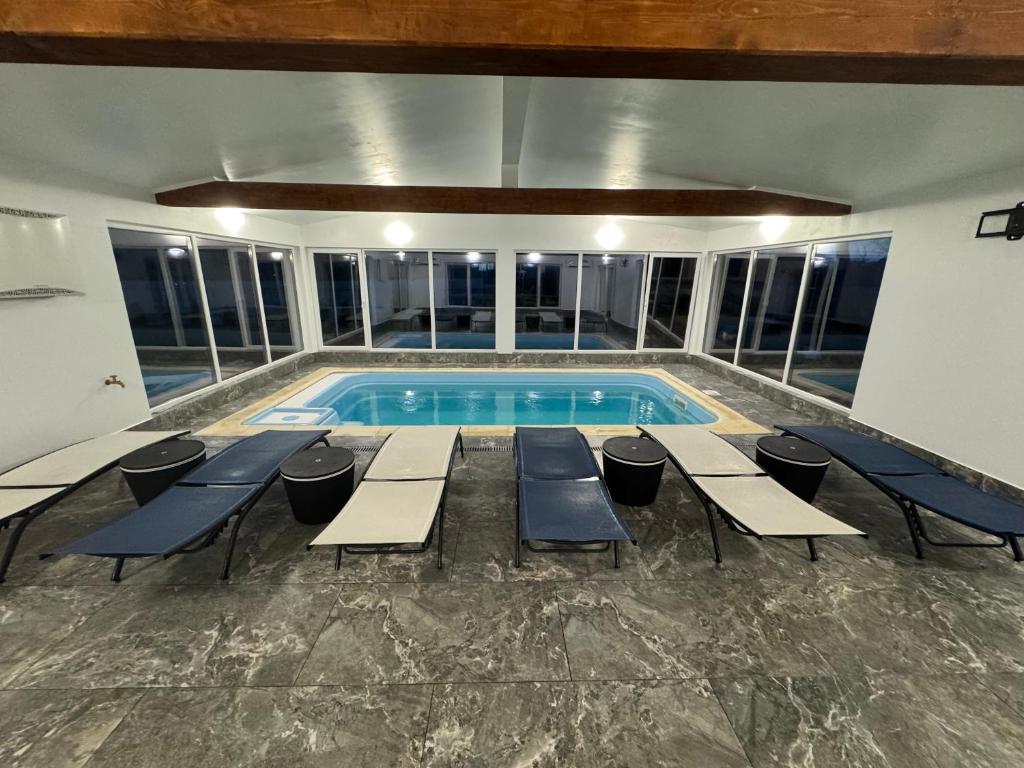 una piscina con tavoli e sedie in un edificio di Cabana Erta a Tireu