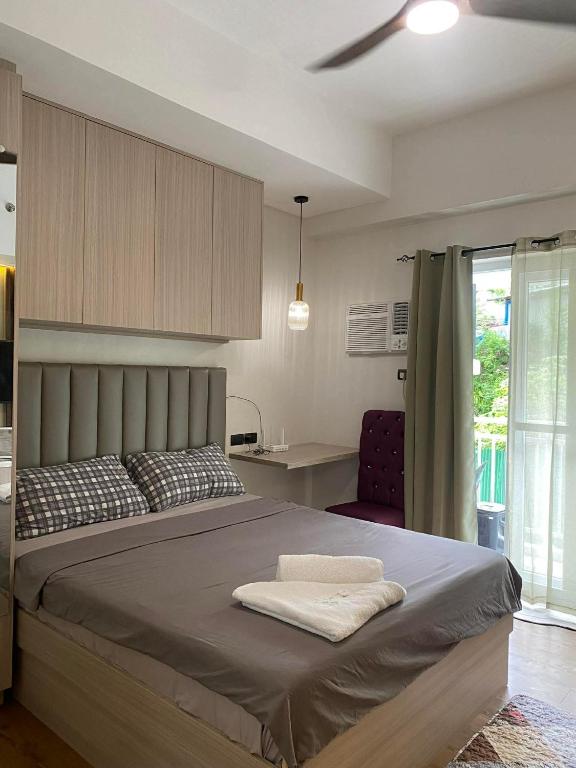 a bedroom with a large bed and a kitchen at Lauriz Place at Amani Grand Resort and Residences in Lapu Lapu City