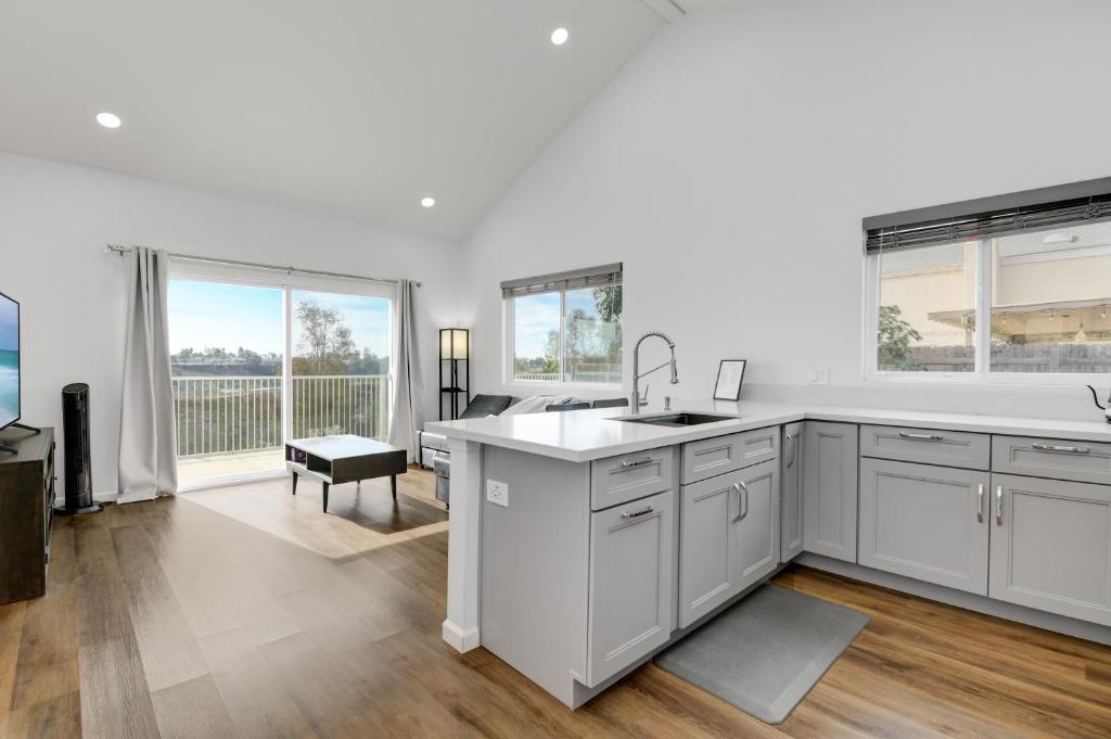 a kitchen with white cabinets and a sink at Bright Spacious Modern Getaway in San Diego