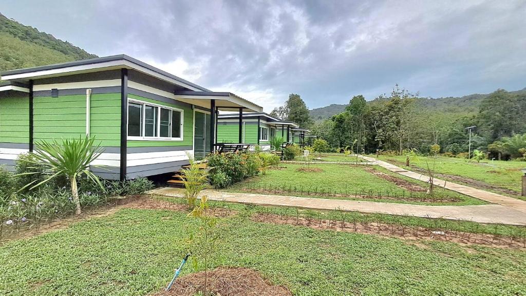 ein kleines grünes und weißes Haus mit einem Hof in der Unterkunft Greenview Room and Restaurant 