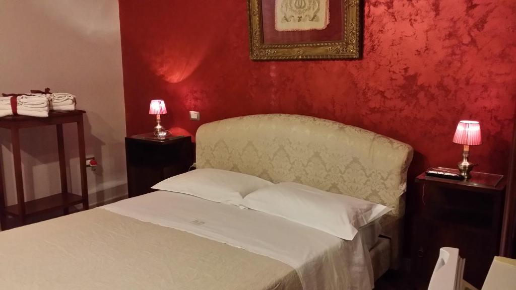 a bedroom with a white bed with red walls at Sorelle De Filippis in Salve