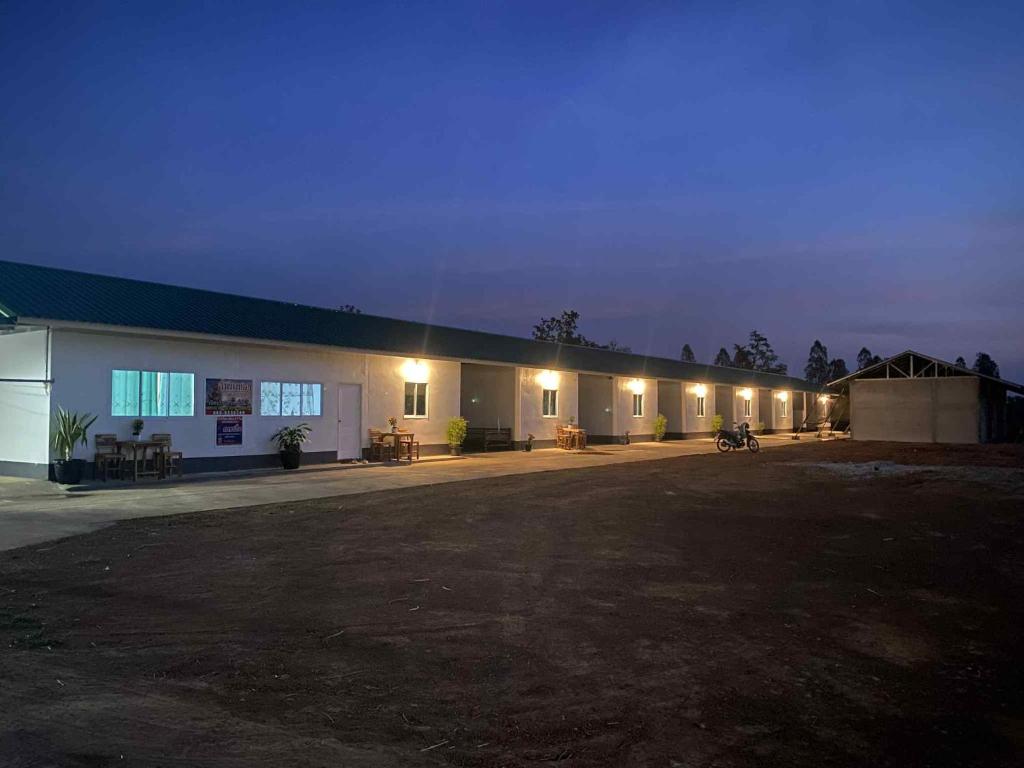a building with lights in a parking lot at night at สำเภาทองรีสอร์ท in Ban Don Sai