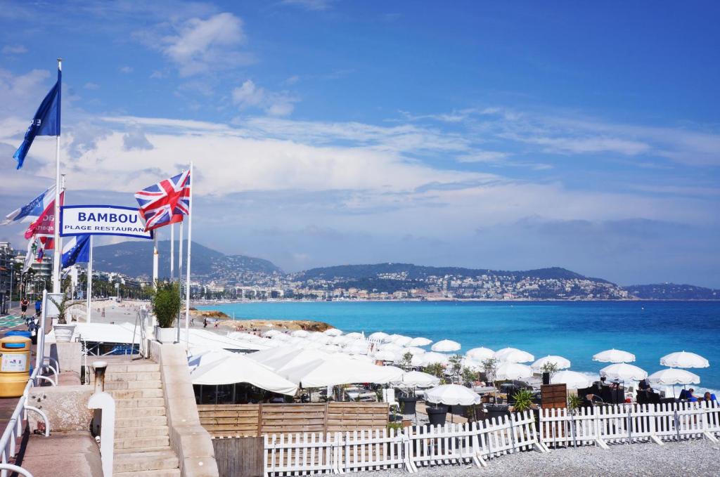 une plage avec un tas de parasols et l'océan dans l'établissement Cosy apartment Promenade des Anglais, à Nice