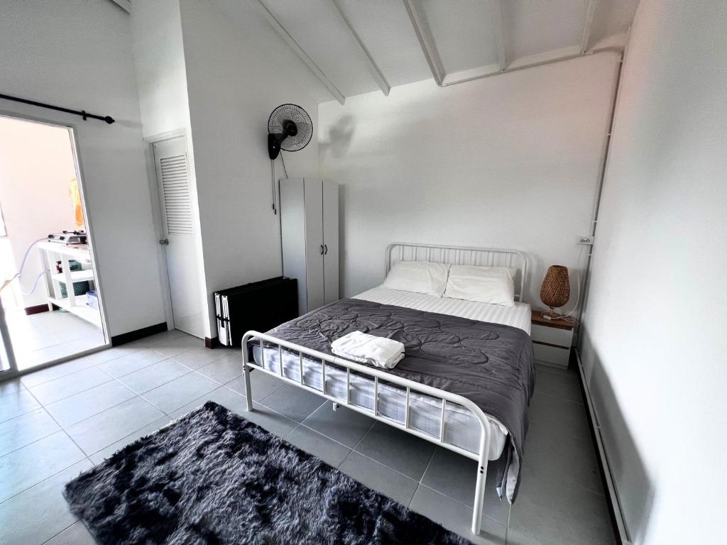 een witte slaapkamer met een bed in een kamer bij Koh Lipe Apartment in Satun