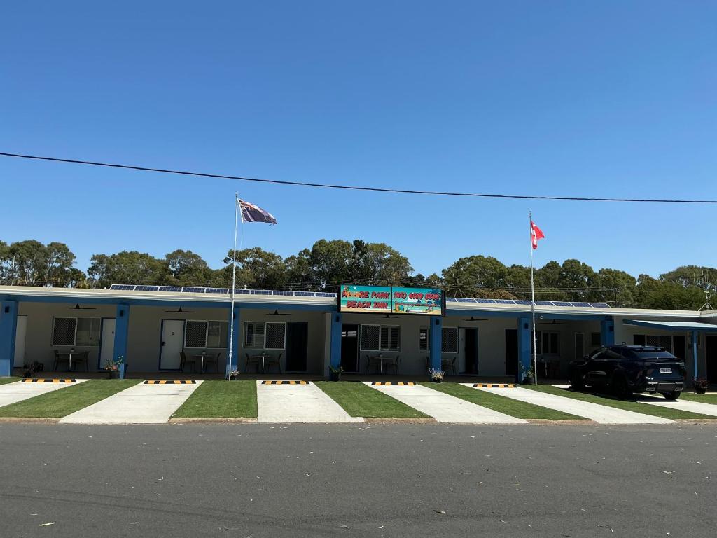 a building with two flags in front of it at Moore Park Beach Inn in North Coast