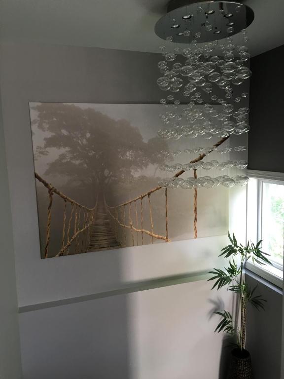 a painting of a suspension bridge hanging on a wall at Gîte Zazen in Mont-Laurier