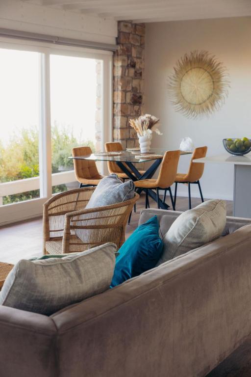 a living room with a couch with chairs and a table at Fabella Serenety Flat in Muizenberg