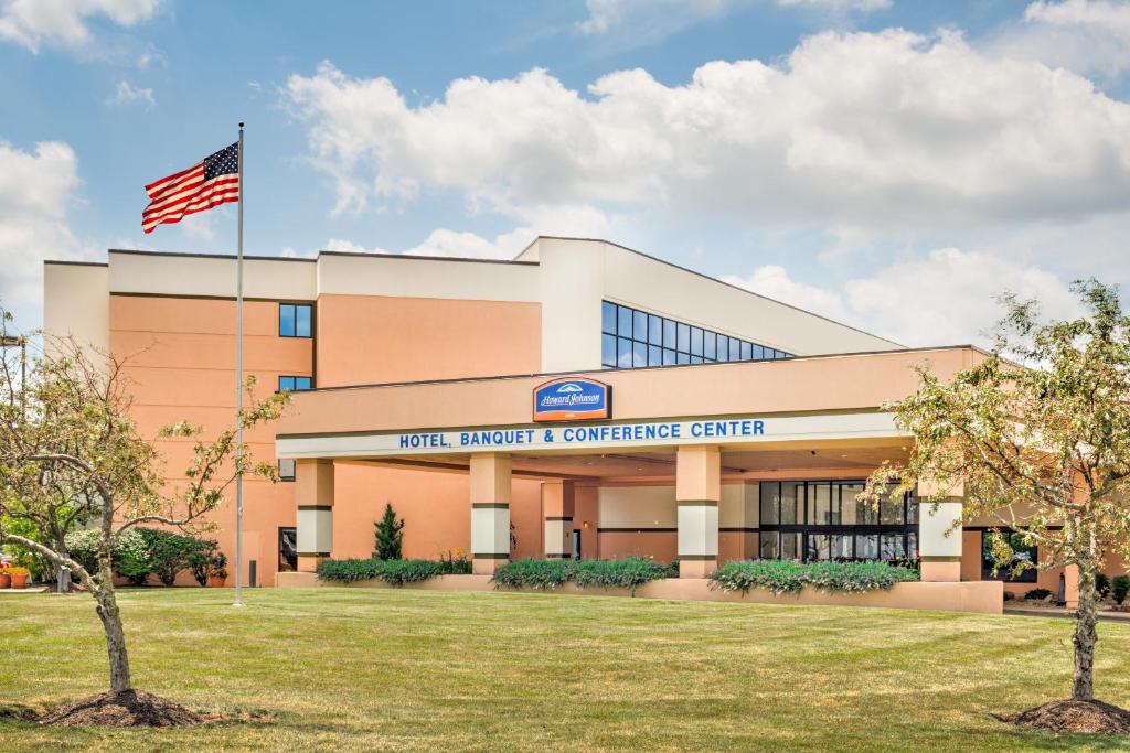 an office building with an american flag in front at Howard Johnson by Wyndham Lima in Lima