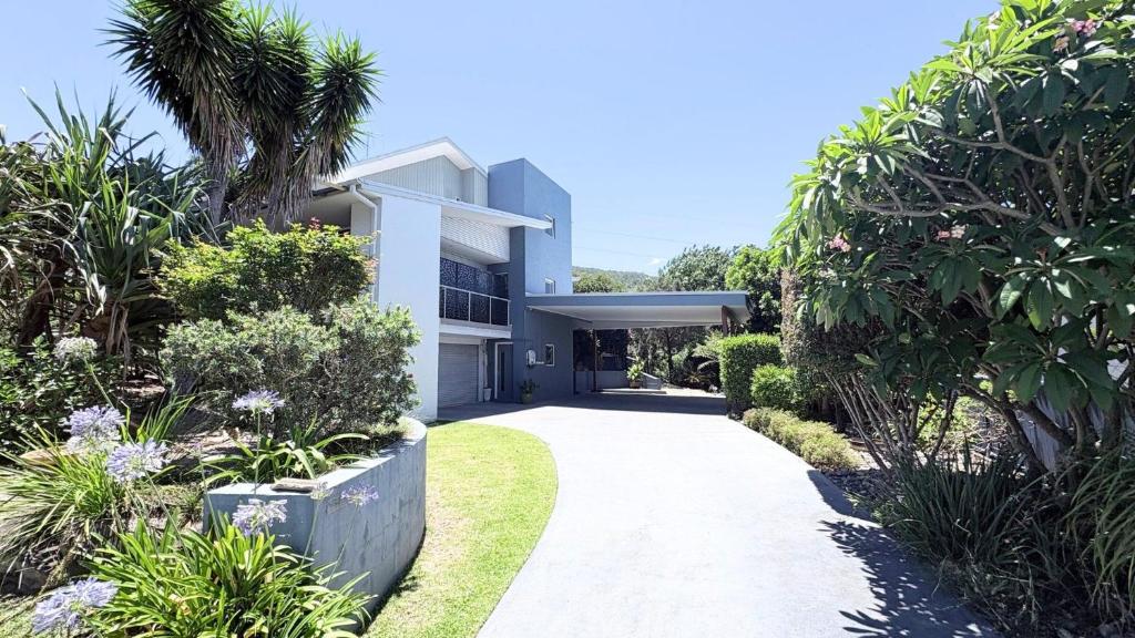 a white house with a walkway in front of it at Station on Pearce in Coffs Harbour