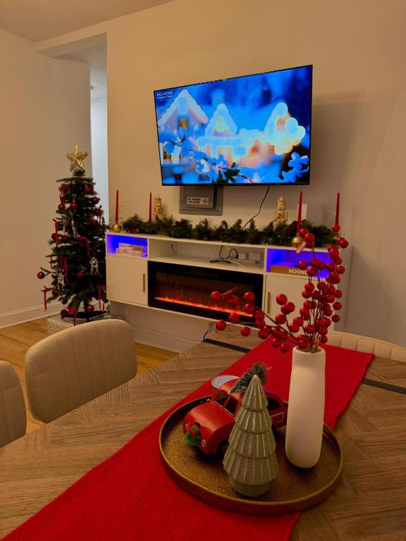 a living room with a christmas tree and a television at Spacious 3BR Apartment - 12min Newark Airport -Near NYC & Malls in Newark