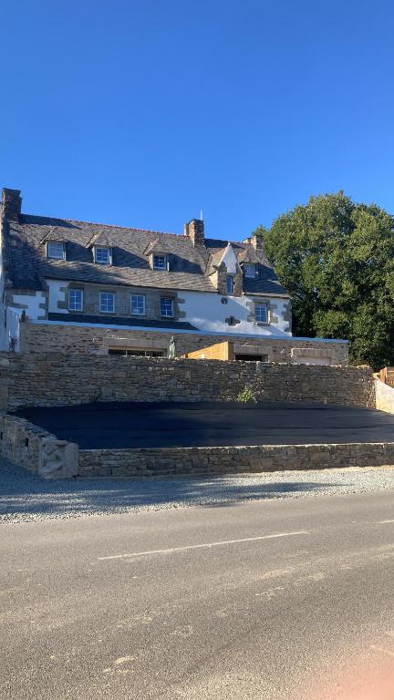 a building on the side of a road with a street at Moulin entier rénové in Plounéventer
