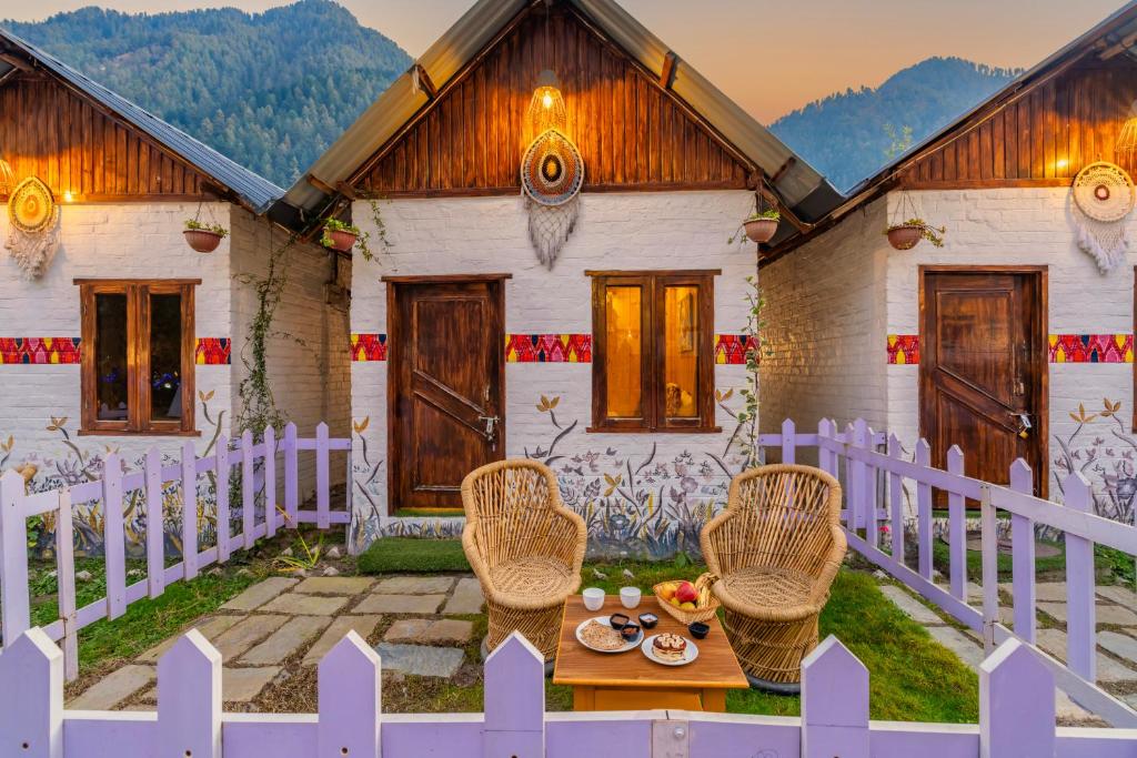 a house with a table and chairs and a fence at Himtrek Stays Katagala in Kasol