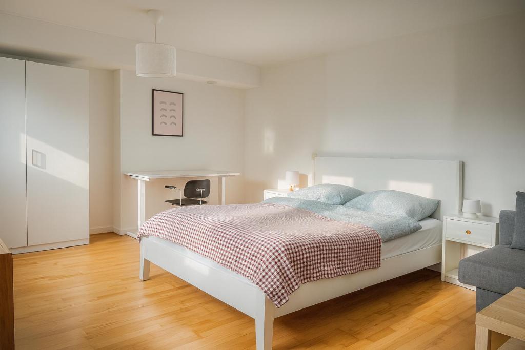 a white bedroom with a bed with blue pillows at Villa Room in Malmö