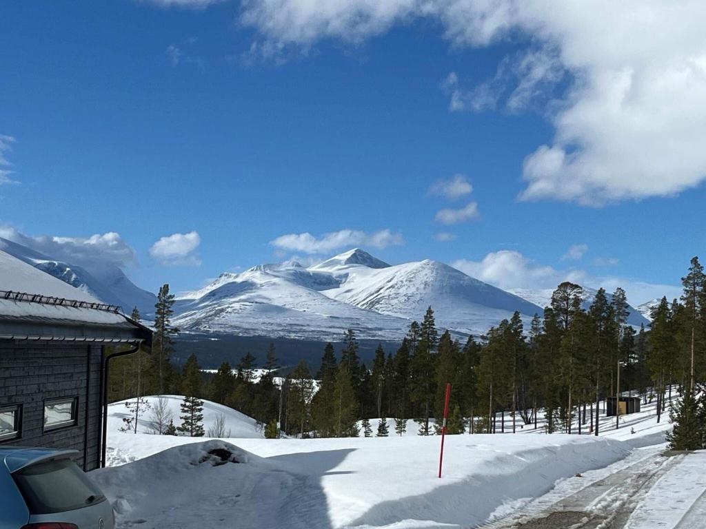 a snow covered mountain in front of a house at 6 person holiday home in Sollia-By Traum in Brenn