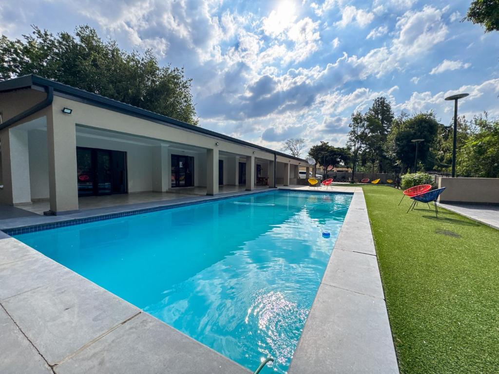 a swimming pool in a yard next to a house at Berrybliss Guesthouse - Sandton in Sandton
