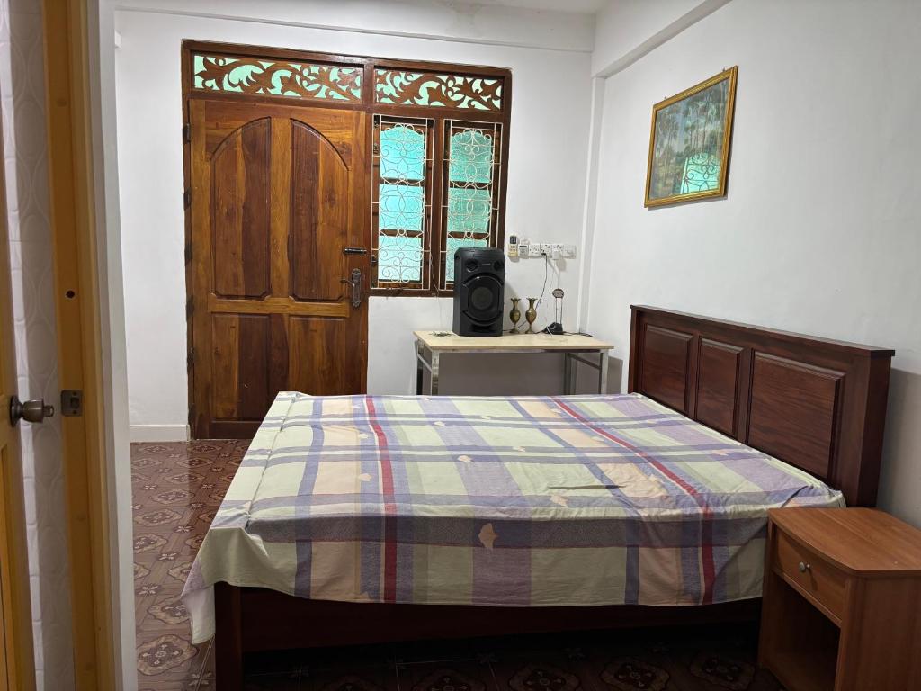 Un dormitorio con una cama y una ventana y una puerta. en Sj Hotel Jaffna, en Jaffna