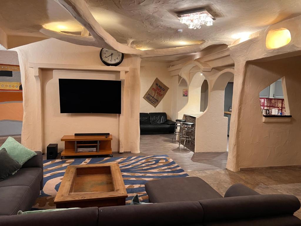 a living room with a couch and a flat screen tv at Villa Stern bei FFM Viel Platz und eigener Zugang in Nidderau