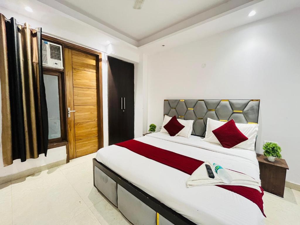 Un dormitorio con una cama grande con almohadas rojas. en Hotel Milton -Malviya Nagar, en Gurgaon