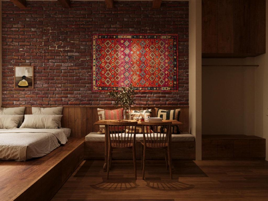 a room with a table and a brick wall at PhaTea Neoclassical Style Building - near Old Quarter in Hanoi