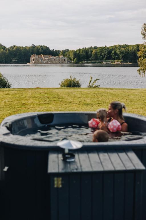 a woman and a child sitting in a hot tub at Laimeskalni in Koknese