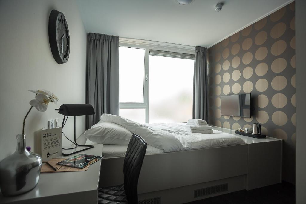 um quarto com uma cama, uma escrivaninha e uma janela em Stravinsky Slapen em Hengelo