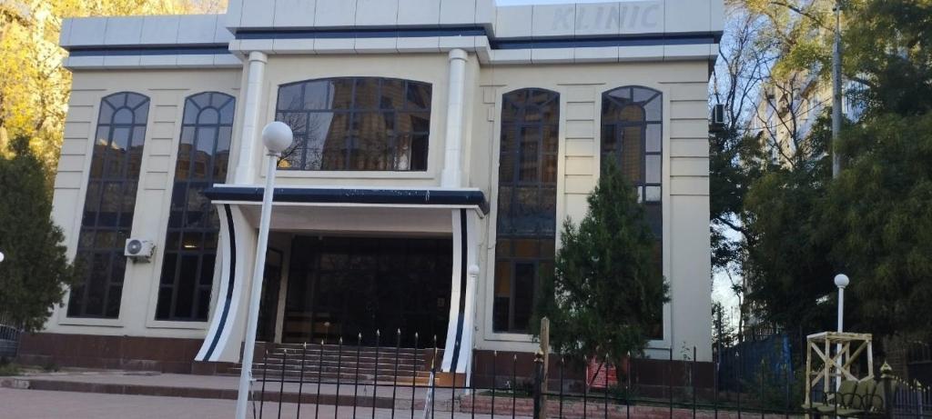 a large white building with a gate in front of it at Oq uy Hostel Chilonzor in Tashkent