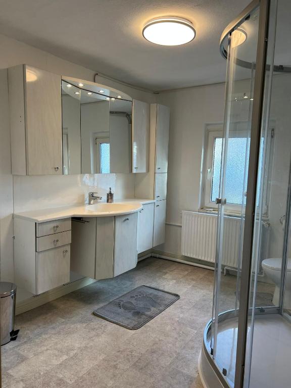 ein großes Badezimmer mit Waschbecken und Dusche in der Unterkunft Boxenstop Ossendorf in Warburg