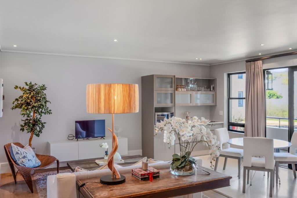 The gallery luxury one bedroom apartment unit 101 في كنيسنا: غرفة معيشة مع طاولة وغرفة طعام