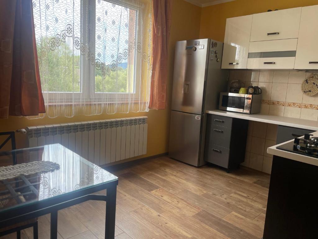 a kitchen with a refrigerator and a table and a window at Przy Szlaku in Cisna