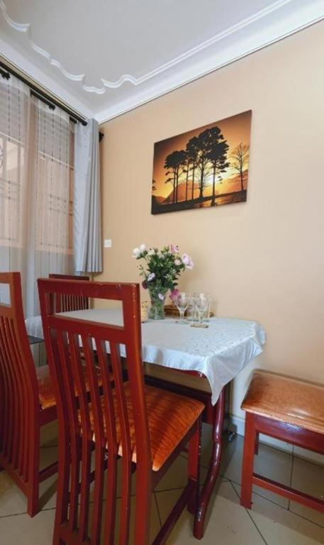 a dining room with a table and chairs and a picture of trees at Serenity Homes in Kampala