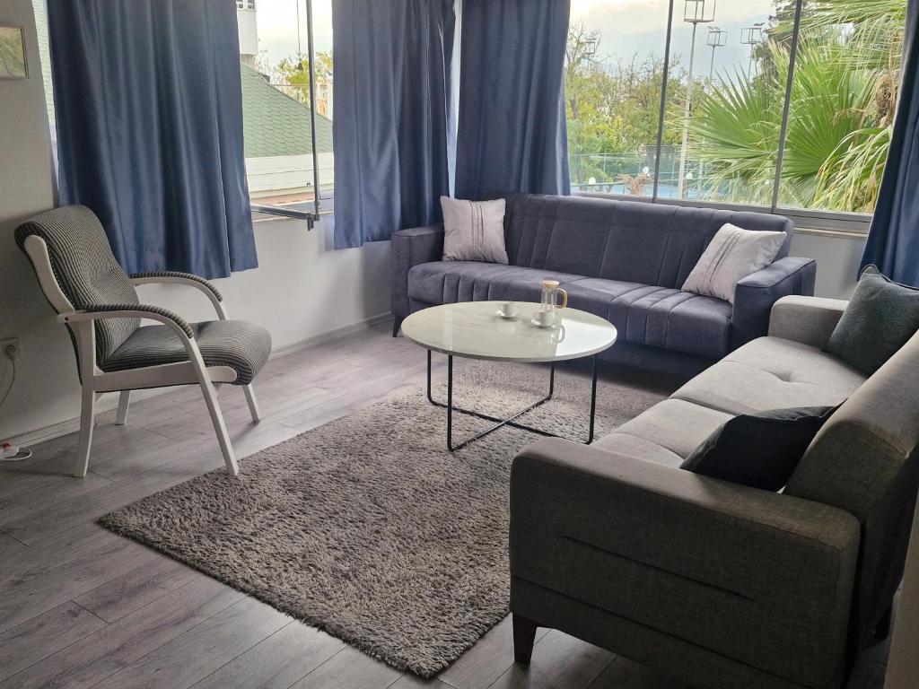 a living room with a couch and a table and chairs at Apartment close to the sea in the most central of city in Antalya