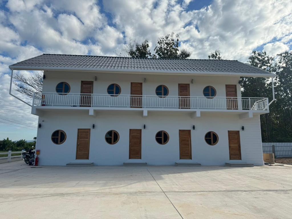 un edificio bianco con finestre rotonde e un balcone di The9motel a Ngao