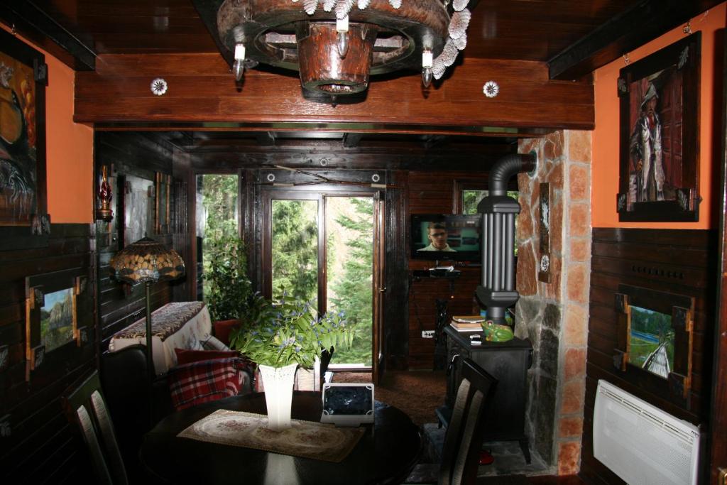 uma sala de jantar com uma mesa e um quarto com uma janela em Durmitor Chalet em Žabljak