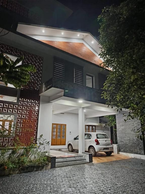 a white car parked in front of a house at Aathira Agri Homes in Trichūr
